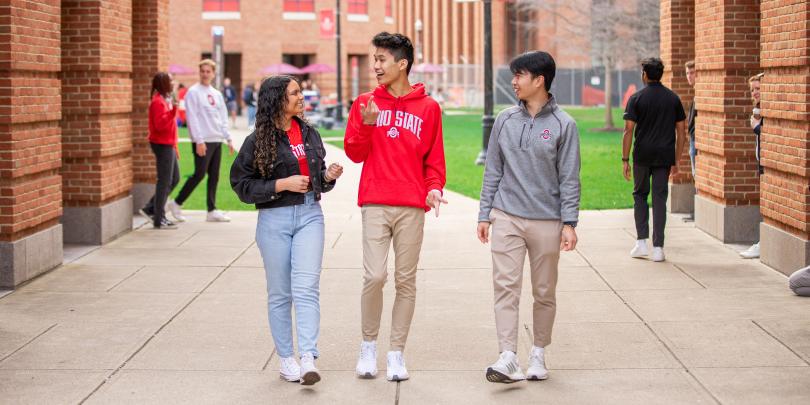 Three students walking on Fisher's campus and smiling